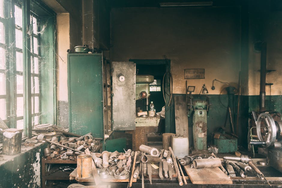 A vintage workshop filled with dusty machinery and tools, depicting industrial decay.