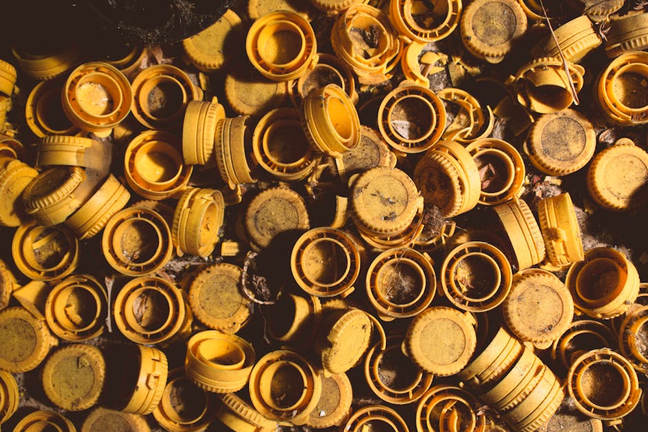 A pile of discarded yellow plastic bottle caps in an abandoned setting, showcasing urban decay.